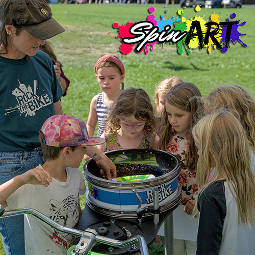 Children being shown by an adult how to use the Spin Art product.